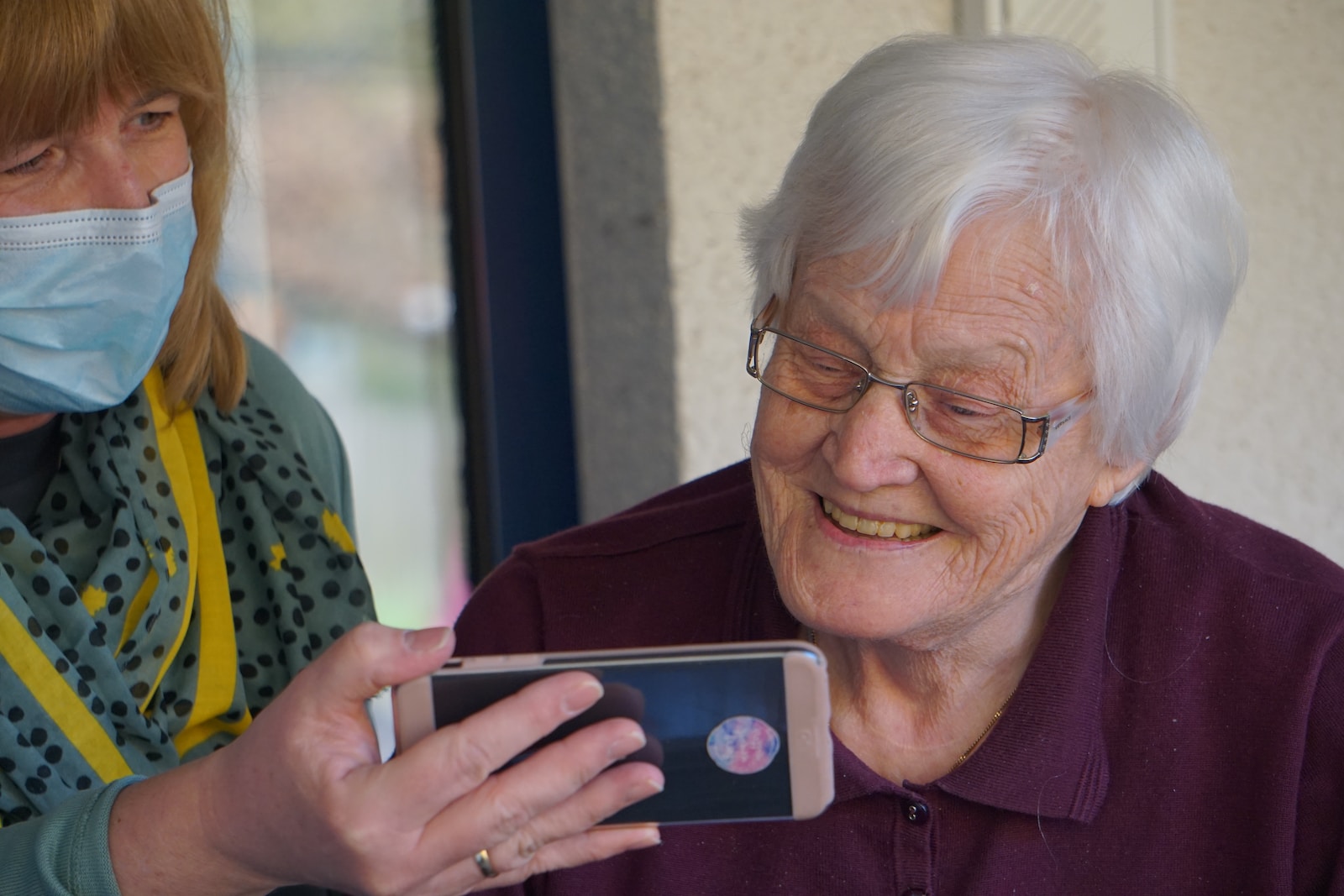 woman in brown button up shirt holding white smartphone Emergency Services for Seniors