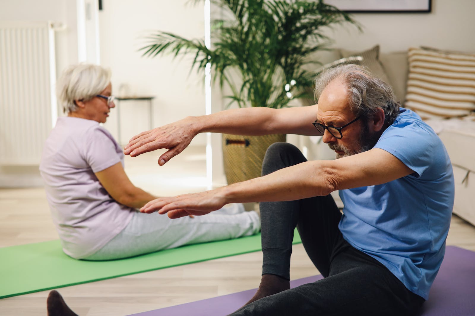 Elderly Couple Sitting on Yoga Mats Exercises for Seniors With Arthritis
