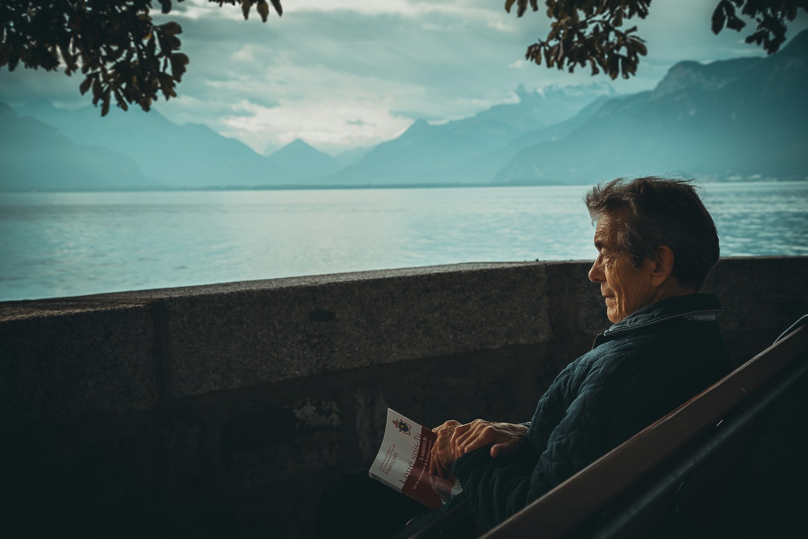 man sitting while holding a book watching on body of water Guided Imagery for Relaxation