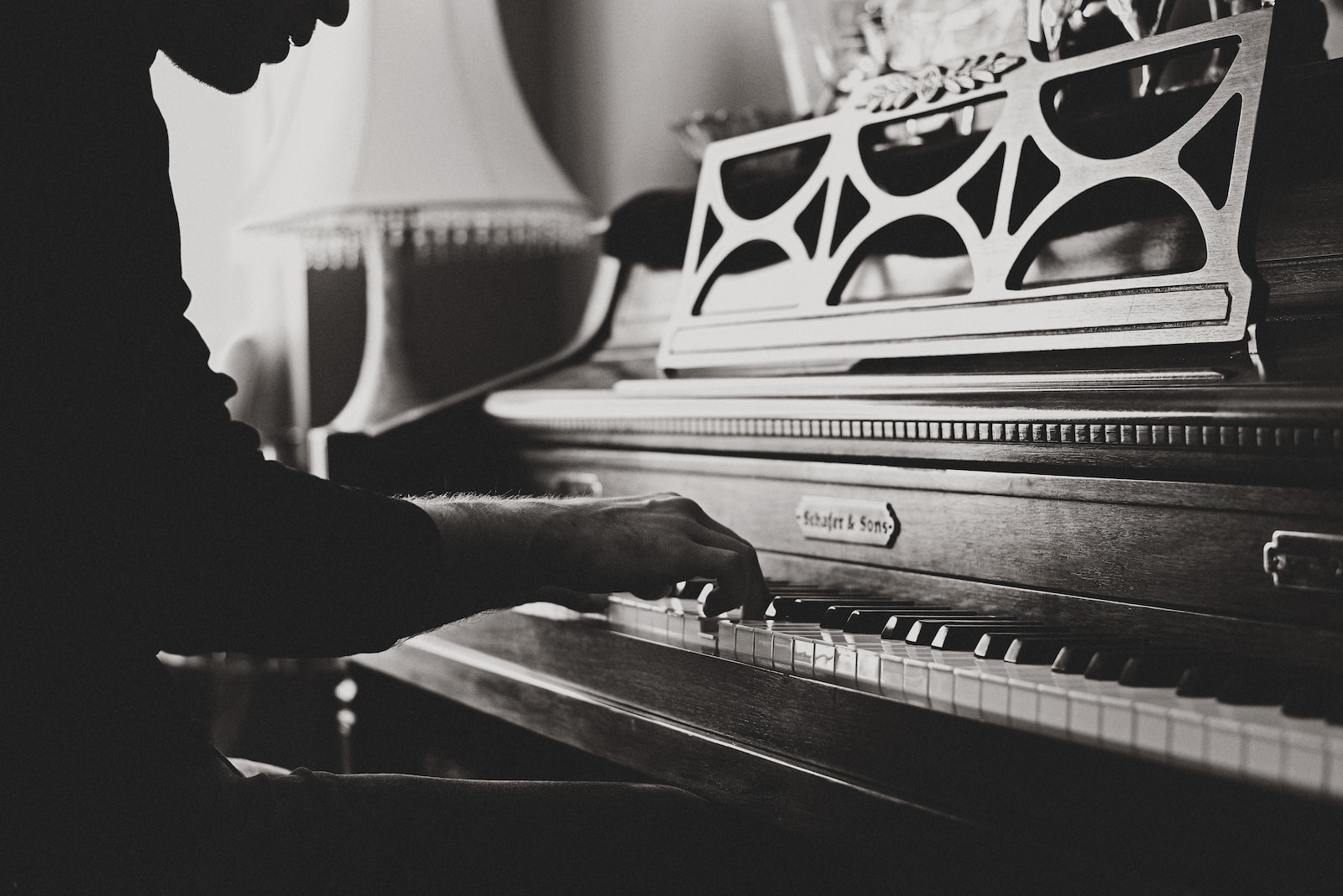 greyscale photo of man playing spinet piano close-up photo Music Therapy in Senior Care