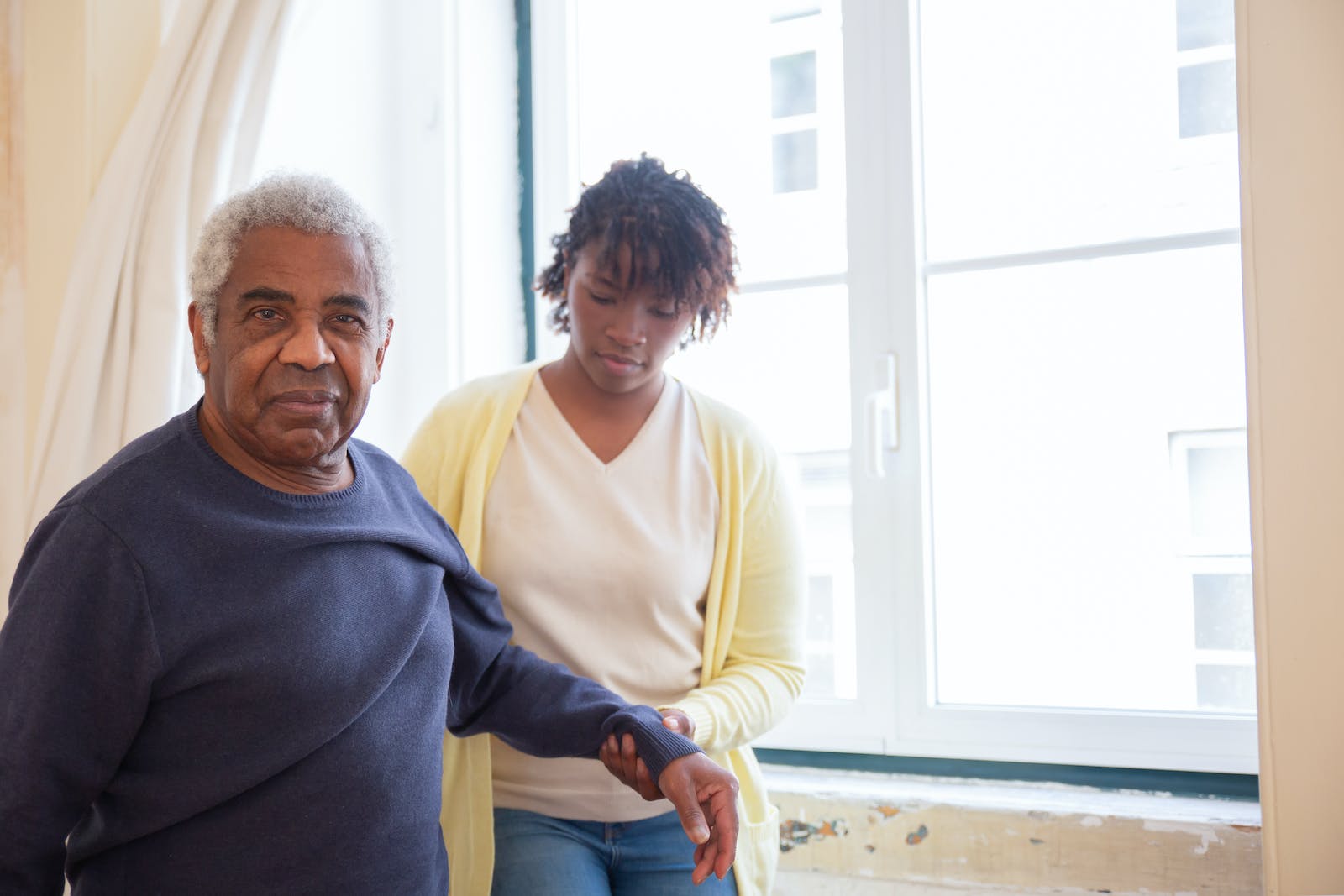 A Woman in Yellow Cardigan Holding the Man's Arm Understanding Respite Care